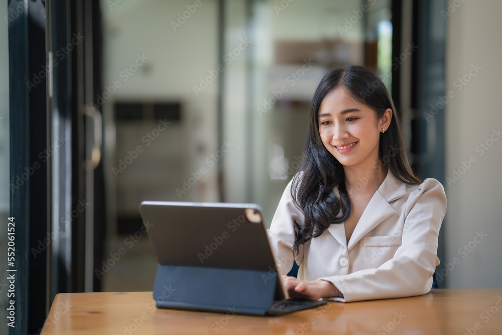 Attractive Asian young businesswoman using or working on a digital tablet computer. Attractive Asian young businesswoman using or working on a digital tablet computer.
