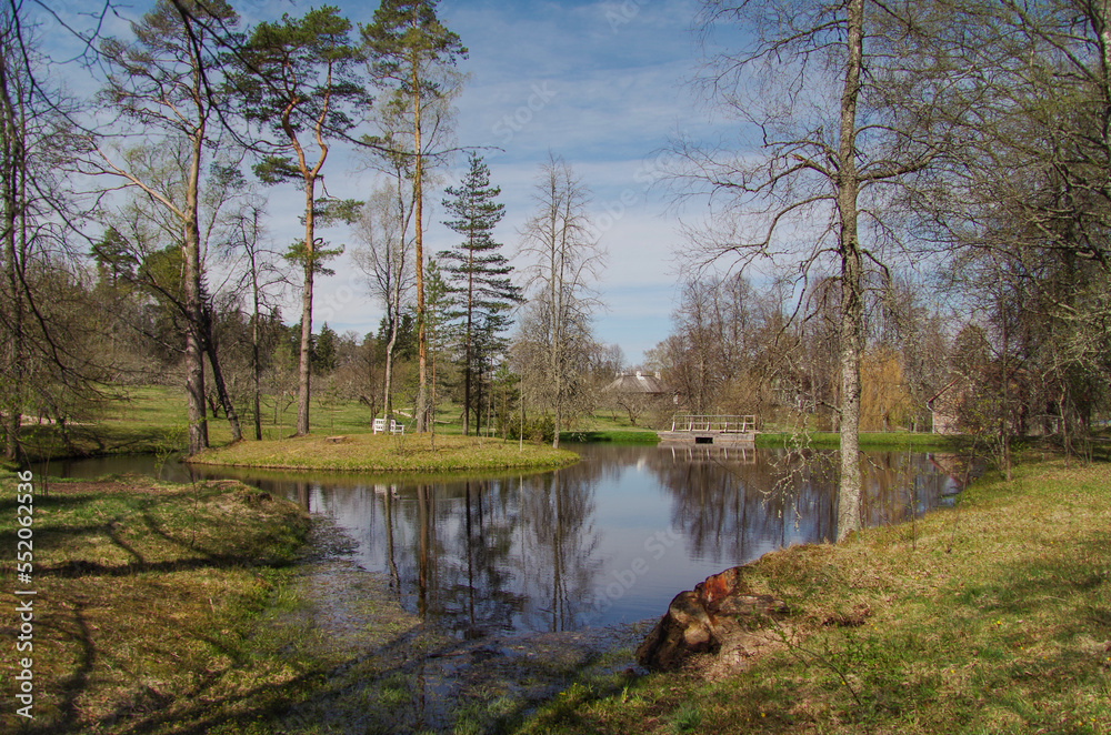 Isle of Seclusion. Small island with pines in middle of round pond. Park in Mikhailovskoye. Pushkinskie Gory. Russia, Pskov region, historical Pushkin places Isle of Seclusion. Small island with pines in middle of round pond. Park in Mikhailovskoye. Pushkinskie Gory. Russia, Pskov region, historical Pushkin places