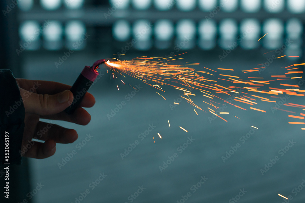 Burning Firecracker with Sparks. Guy Holding a Petard in a Hand. Loud