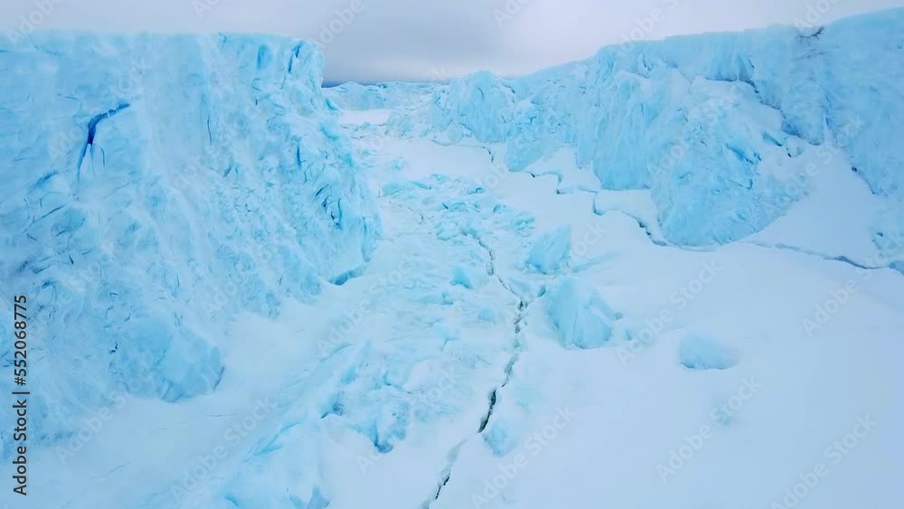 Snow covered antarctic surface aerial view flight. Desert white land of snow and ice drone shot. Frozen south pole. Snow covered antarctic surface aerial view flight. Desert white land of snow and ice drone shot. Frozen south pole.