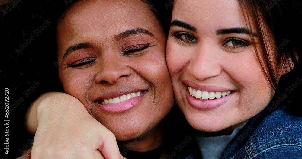 Two diverse girlfriends cheek to cheek, happy millennials, diversity concept Two diverse girlfriends cheek to cheek, happy millennials, diversity concept