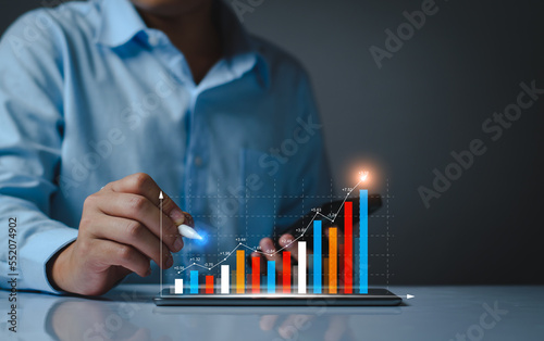 Businessman analysis profitability of working companies with digital augmented reality graphics, positive indicators in 2023, businessman calculates financial data for long term investments.