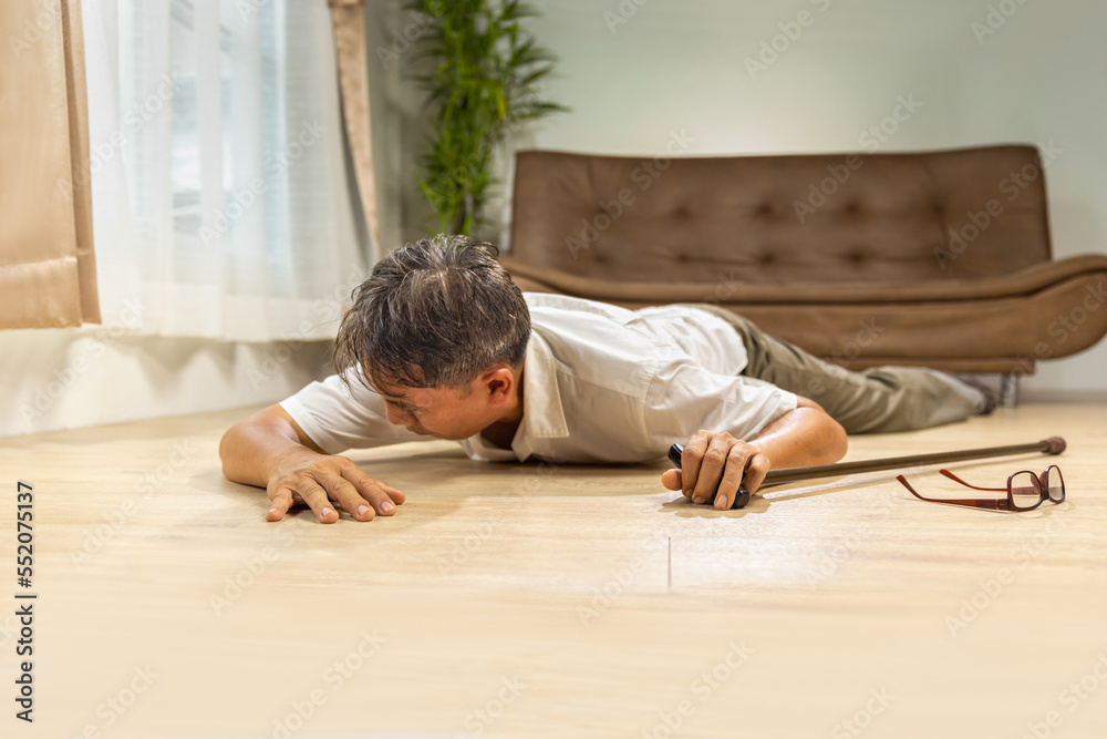 Asian senior man falling down and lying on the floor while walk with walking stick at home. Asian senior man falling down and lying on the floor while walk with walking stick at home.