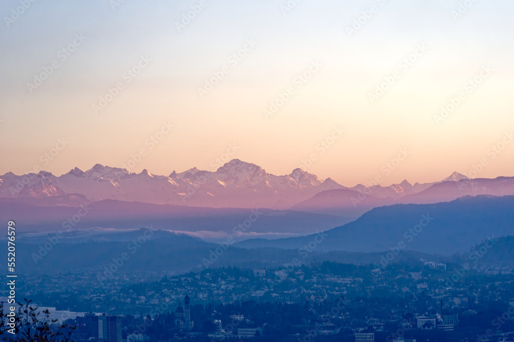 Aerial view over City of Zürich with Lake Zürich and Swiss Alps in the background on a sunny autumn evening. Photo taken December 6th, 2022, Zurich, Switzerland.