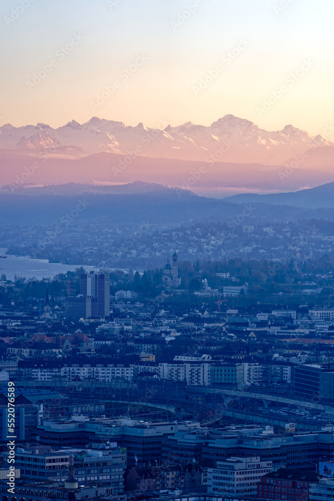 Aerial view over City of Zürich with Lake Zürich and Swiss Alps in the background on a sunny autumn evening. Photo taken December 6th, 2022, Zurich, Switzerland.