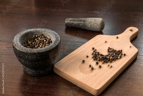 Peppercorns with granite mortar. Pepper spice 