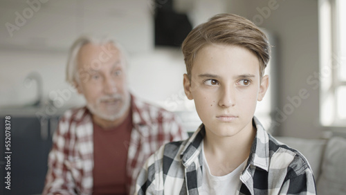 Sad boy ignoring his shouting grandfather, generation gap, misunderstanding