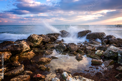 Stunning seascape with scenic clouds over the sea with rocky shore