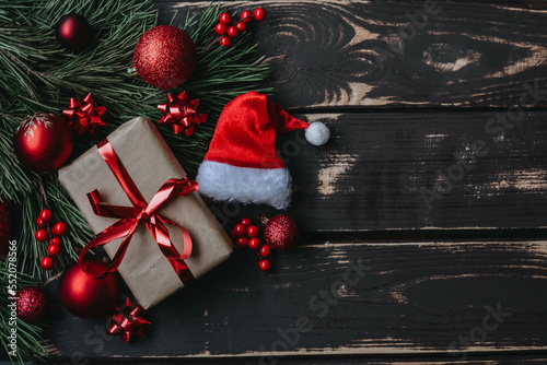 Christmass background gift boxe,red christmas tree toys,Santa hatn and spruce brance on wooden background. photo