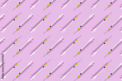Creative pattern of injection syringes. Top view and pink background. Disposable medical syringes with needle. Applicable to vaccine injection. Single use syringe. Space for copy.