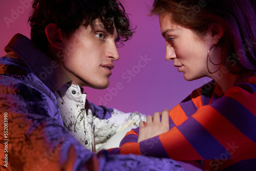 Loving young couple looking at each other in projector light photo