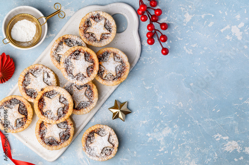 Traditional Christmas dessert with dried fruits - mince pies on a blue background. Top view