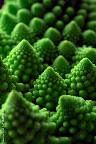 Green vegetable background of Romanesco cabbage. Romanesco cabbage close-up. Agricultural business. Growing vegetables. Plant growing.