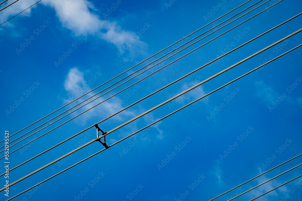 Fototapeta premium High voltage wires with blue sky background, current station lines