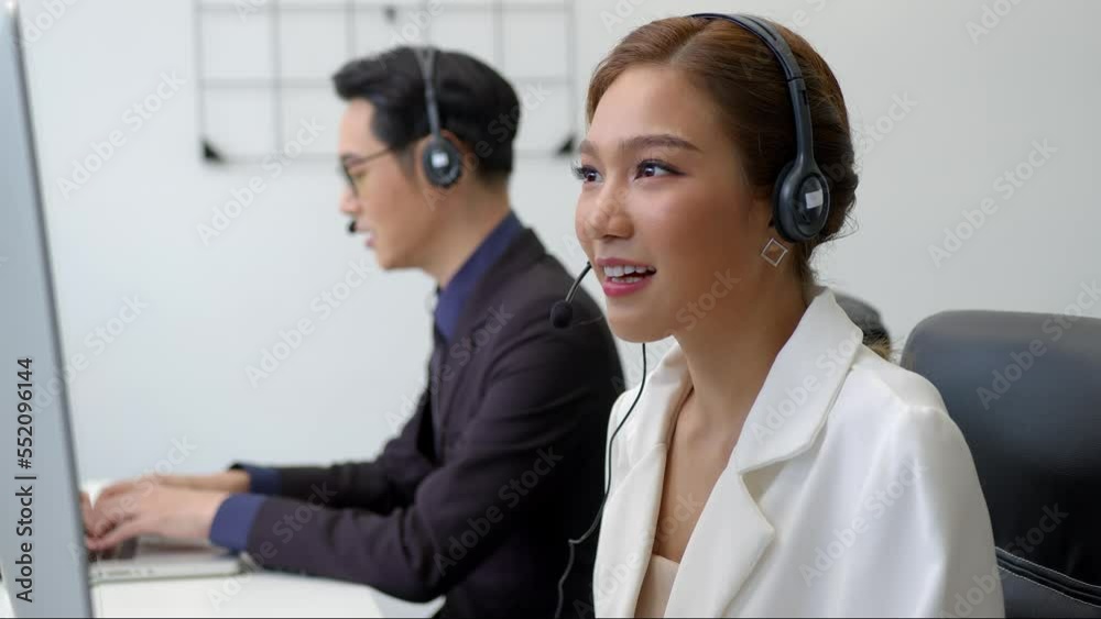 Asian call center team, customer service, wearing headset or headphone talking with customer in in a call centre office. Asian call center team, customer service, wearing headset or headphone talking with customer in in a call centre office.
