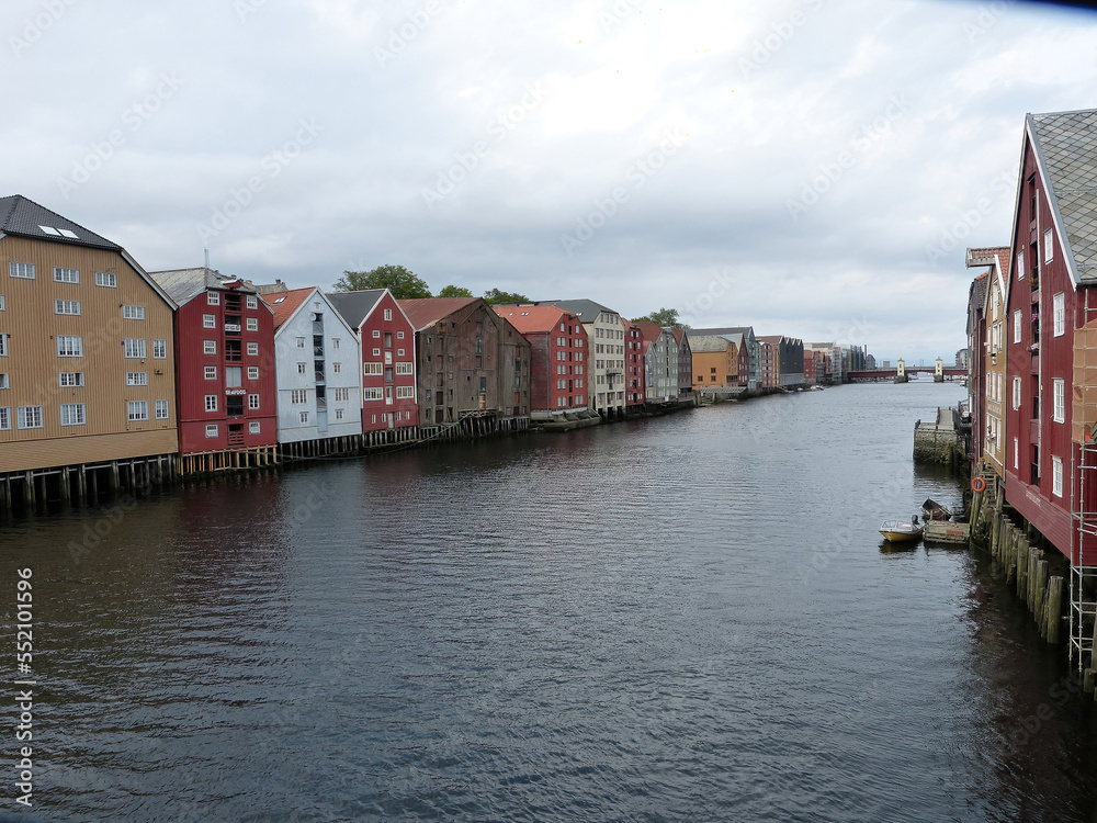 View of a traditional row of houses in Norway with a river in the middle.