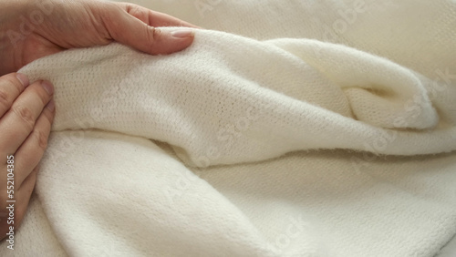 Photography female's hand on the fabric of white plush cloth with soft nap