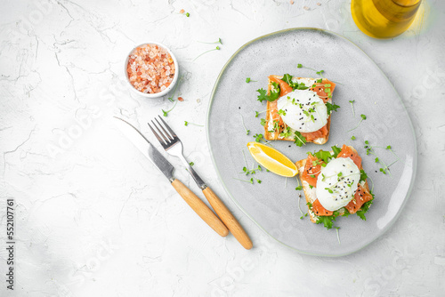 healthy breakfast with poached eggs, salmon and guacamole on toast. place for text, top view