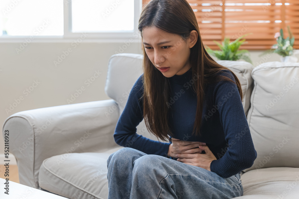young woman gripping her stomach have abdominal pain . young woman gripping her stomach have abdominal pain .