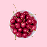 Viva Magenta color of the year 2023. .Close-up of ripe cherries on a pink background.