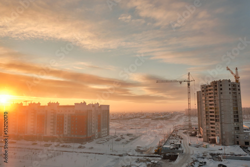 Construction of multi-storey residential buildings at dawn in winter