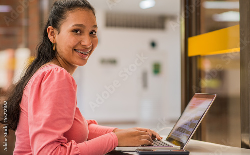 joven trabajando en computador, mujer investigando en su computador 