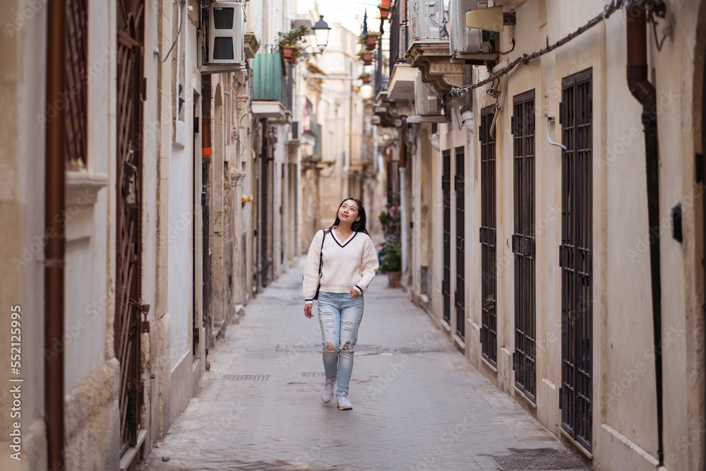 Ethnic woman strolling during trip in aged city Ethnic woman strolling during trip in aged city