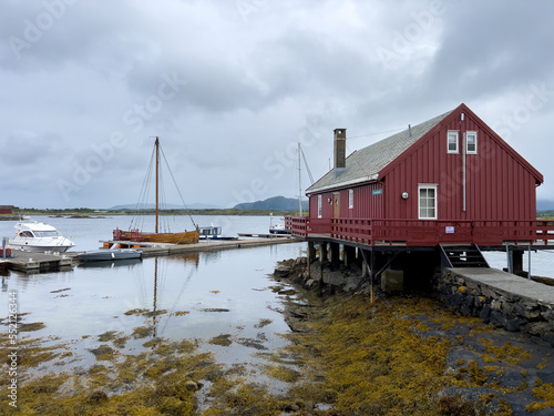 old red house at the shore of the Atlantic ocean with a boat