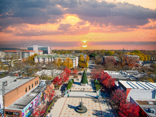 an aerial shot of the Decatur Square with a Christmas tree, red and yellow autumn trees, lush green trees, people and buildings with powerful clouds at sunset in Decatur Georgia USA photo