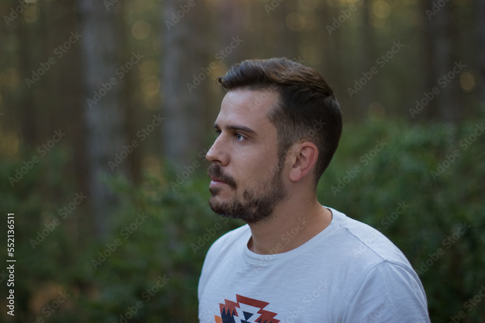 Portrait of a handsome man in the middle of a forest at sunset Portrait of a handsome man in the middle of a forest at sunset