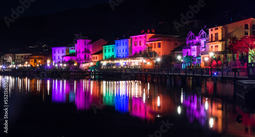 Houses illuminated by searchlights on Christmas night, by colored lights reflecting on the water of the Lake of Lugano