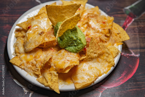 Nachos with cheese and guacamole on a plate