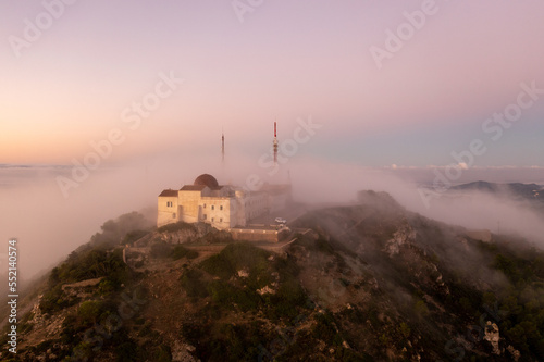4k aerial views with drone. Monastery of Monte Toro, in the centre of the island of Menorca, Balearic Islands.