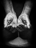 Time is running out: old woman's hands letting sand fall between her fingers symbolizes the hourglass where time is running out. Time is running out concept