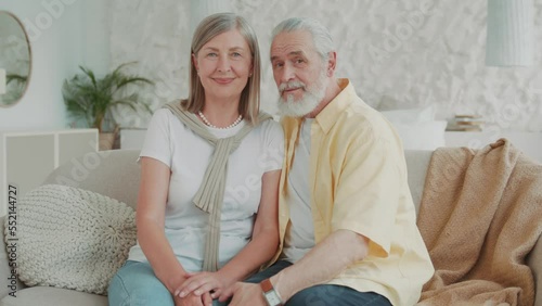 elderly couple smiling and hugging relaxing sitting on the sofa feel happy at home. Family. Modern apartment. Love romance. Portrait. Relationship