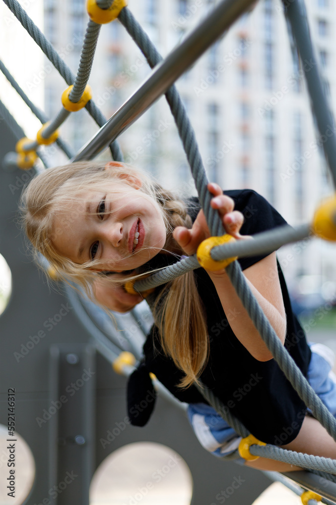 Obraz premium Portrait of a pretty smiling little preschooler girl at the playground.