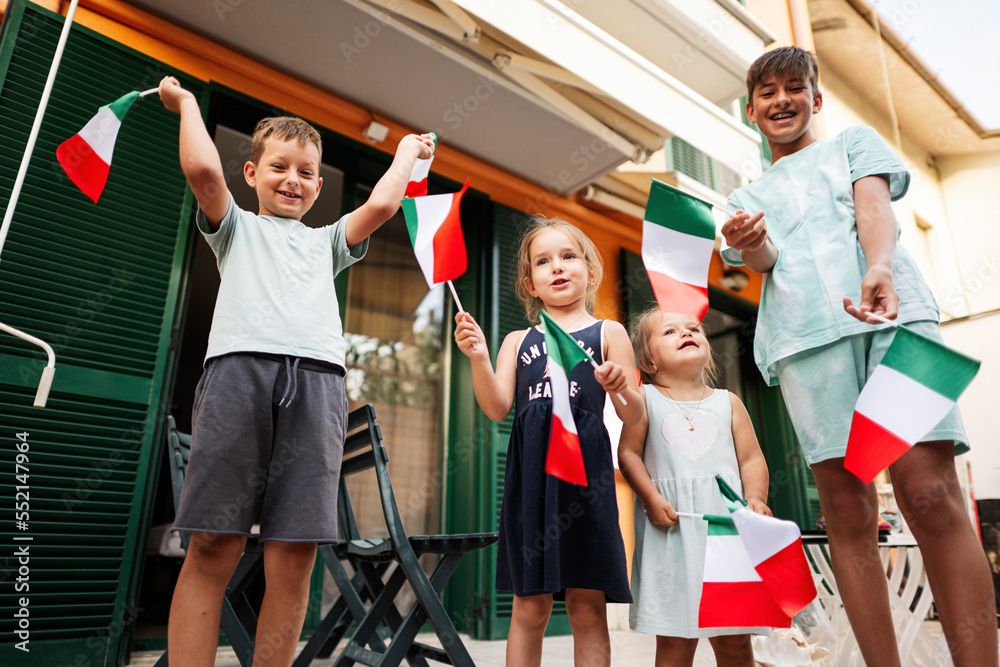 Fototapeta premium Happy four kids with italian flags celebrating Republic Day of Italy.