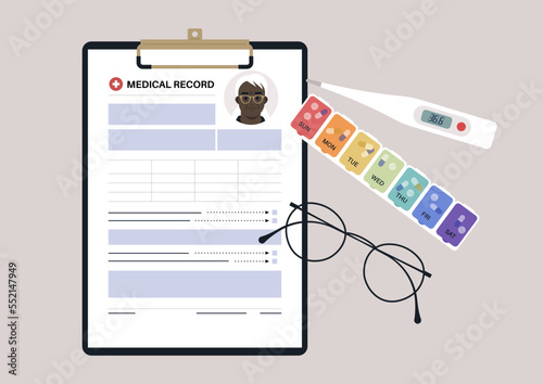 A set of senior patient's medical chart clipped to a clipboard, pill box, glass frames, and plastic thermometer