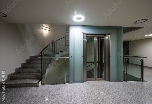 Modern interior of entrance in luxury residential building. Elevator. Staircase.