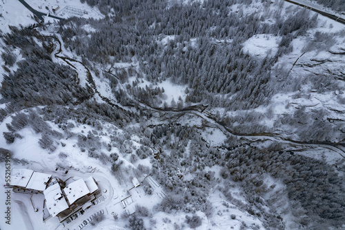 Aerial view of snow-covered pines in the alps, Snow falling on the mountains and frozen lake in the mountains 