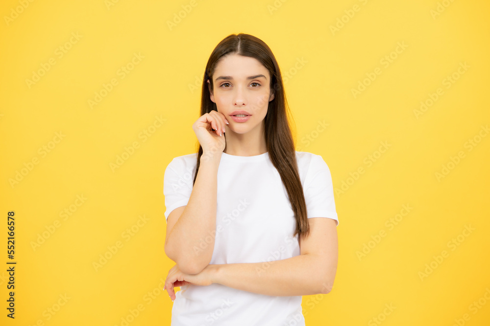 Pretty joyfully female model looking with satisfaction. Studio portrait of looking beautiful woman isolated against yellow background. Pretty joyfully female model looking with satisfaction. Studio portrait of looking beautiful woman isolated against yellow background.