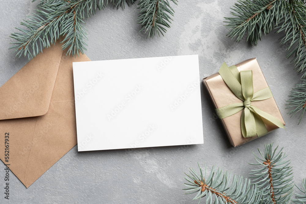 Fototapeta premium Christmas mockup with empty greeting card, fir tree branches and gift box