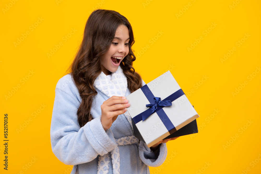 Amazed teen girl. Child with gift present box on isolated background. Presents for birthday, Valentines day, New Year or Christmas. Excited expression, cheerful and glad. Amazed teen girl. Child with gift present box on isolated background. Presents for birthday, Valentines day, New Year or Christmas. Excited expression, cheerful and glad.