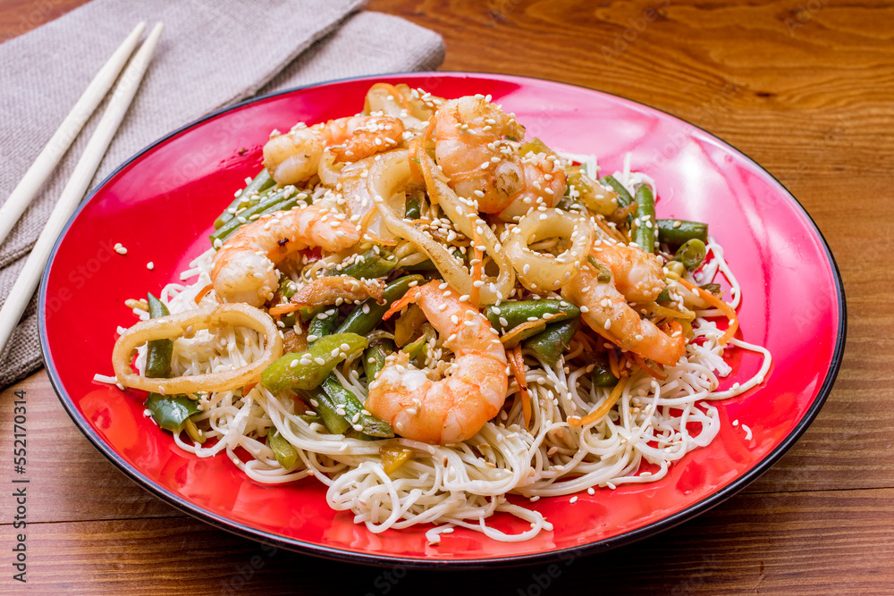 egg noodles with shrimp and vegetables on wooden table egg noodles with shrimp and vegetables on wooden table