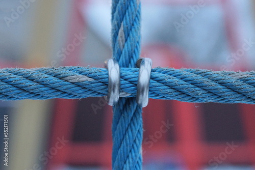 part of blue iron cables with gray metal fasteners with rings on the street