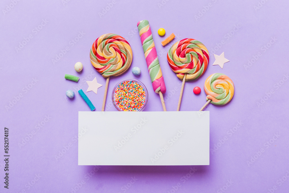 Flat lay holiday composition. Paper blank, lollipop, birthday decorations on Colored background. Top view, copy space for text Flat lay holiday composition. Paper blank, lollipop, birthday decorations on Colored background. Top view, copy space for text