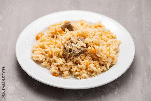 Rice with vegetables and meat on white plate