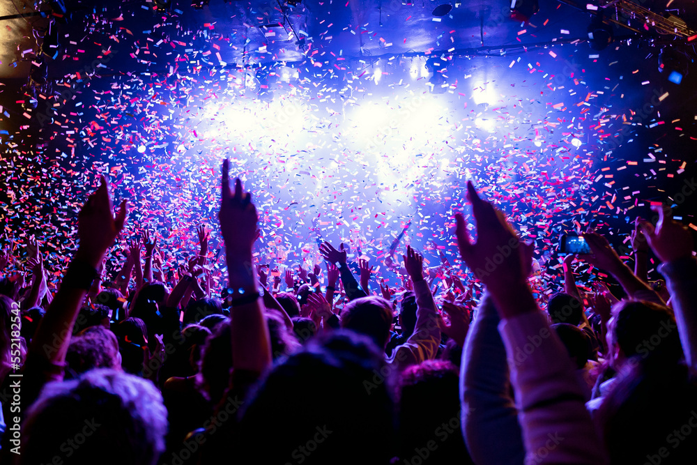 Crowd at a concert celebrating with confetti