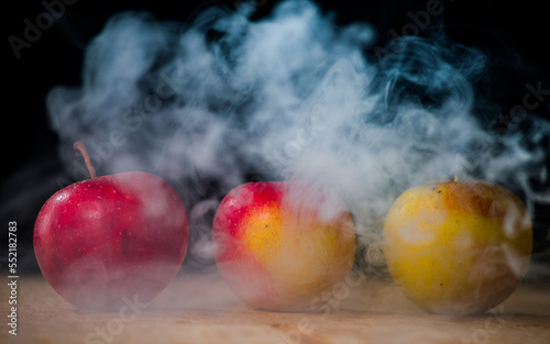 apples like magic in the smoke fresh apples on the table on a dark background filled with magic smoke