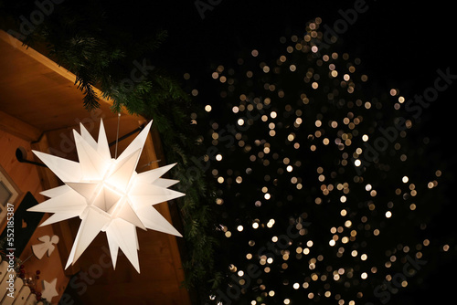 Christmas decoration paper star led lights festive background copyspace christmas mood market stall warm lights bokeh on christmas tree